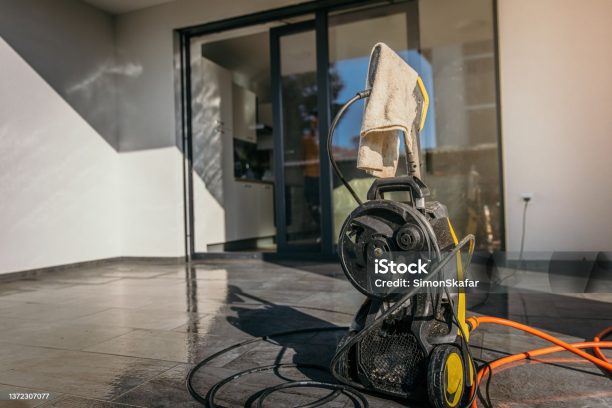 Dirty rag hanging from the high pressure cleaner on the clean terrace of the apartment on sunny day.