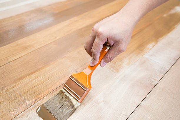 Applying protective varnish on a wooden furniture